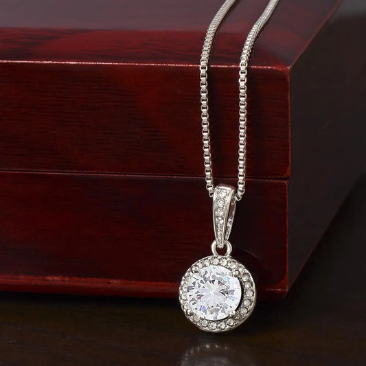  
Close-up of the Eternal Hope white gold solitaire necklace pendant resting against a mahogany-style LED luxury box.